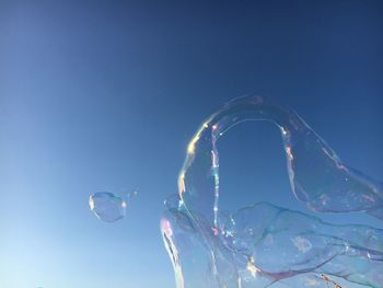 Close-up of bubbles against clear blue sky