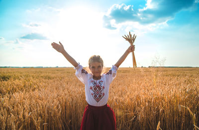 Portrait of girl holding wheat at farm