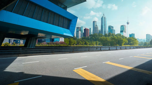 View of city street and modern buildings against sky