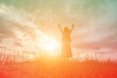 Man standing on field against sky during sunset