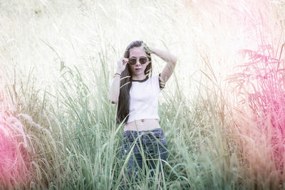 Young woman wearing sunglasses standing on grass