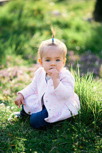 Portrait of cute girl sitting on field