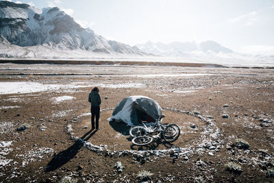 Rear view of man on snowcapped mountain against sky