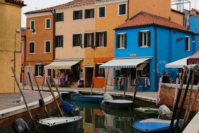 Boats moored on canal by buildings in town