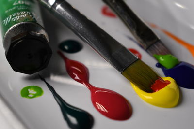 Close-up of of various paints with paintbrush on table
