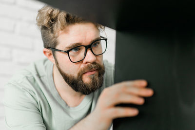 Close-up portrait of young man against wall