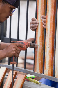 Midsection of man working on metal grate