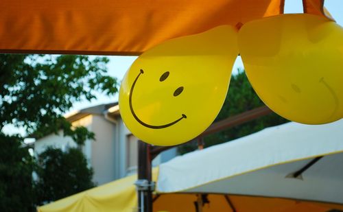 Low angle view of yellow hanging against sky