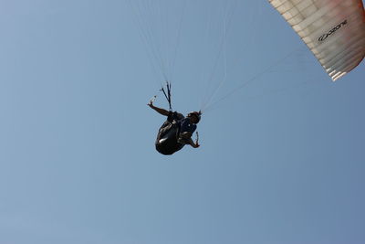 Low angle view of helicopter against clear blue sky