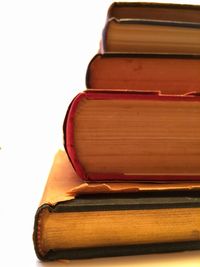 Close-up of books stacked against white background