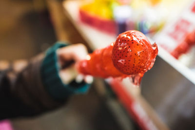 Close-up of hand holding strawberry