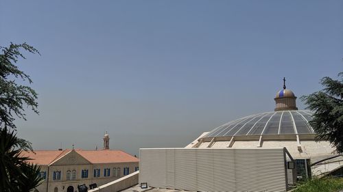 Buildings in city against clear sky