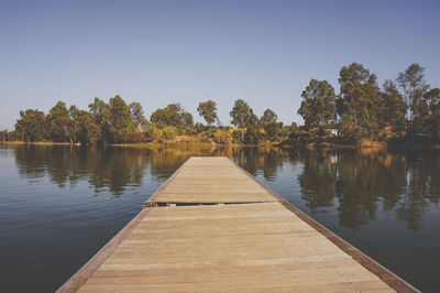 Pier over lake against clear sky