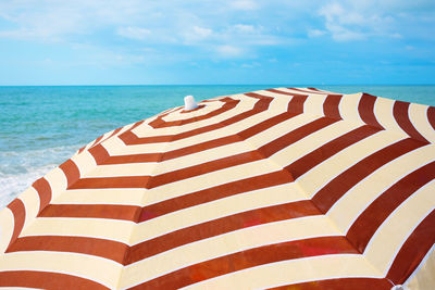 A striped sunshade on the sea beach