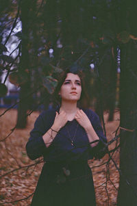 Portrait of young woman looking away in forest