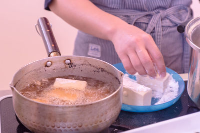 Midsection of woman preparing food in kitchen