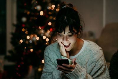 Young woman using mobile phone at home