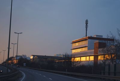 Street amidst buildings against sky at dusk