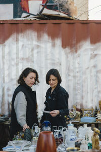 Lesbian couple buying crockery at market stall