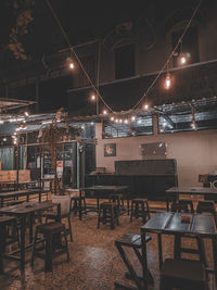 Empty chairs and tables in cafe at night
