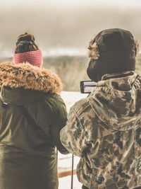 Rear view of woman standing in snow