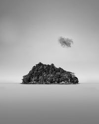 Rock formation in sea against sky