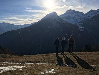 People standing against snowcapped mountains