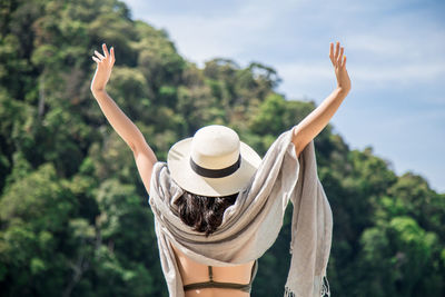 Rear view of woman wearing hat against trees