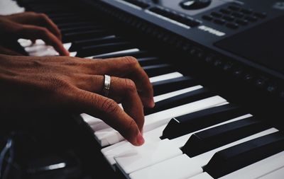 Cropped hands of person playing piano