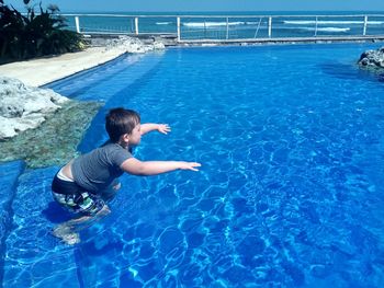 Boy swimming in infinity pool