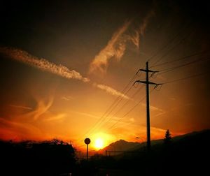 Silhouette of electricity pylon at sunset