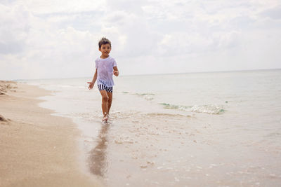 Rear view of woman standing at beach