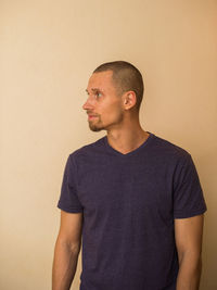 Young man looking away against white background
