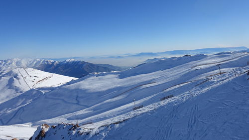 Scenic view of snowcapped mountains against clear blue sky