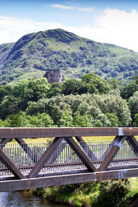 Bridge amidst trees and buildings against sky