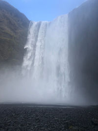 Scenic view of waterfall against sky