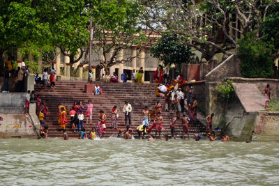 Group of people by river against trees