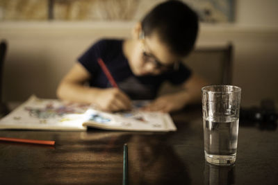 A glass of clean water on the table for drawing boy with glasses