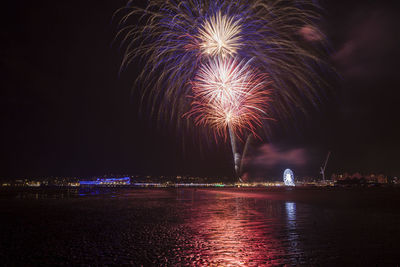 Firework display over river at night