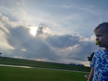 Girl on field against sky