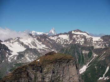 Scenic view of snowcapped mountains against clear blue sky