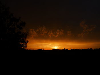 Silhouette of landscape against cloudy sky