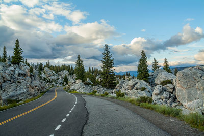 Road amidst trees against sky