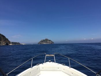 Sailboat sailing in sea against blue sky