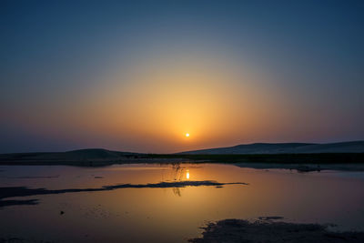 Scenic view of lake against sky during sunset