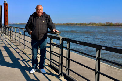 Low section of man standing on railing