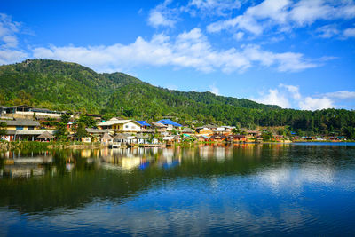 Scenic view of lake by buildings against sky