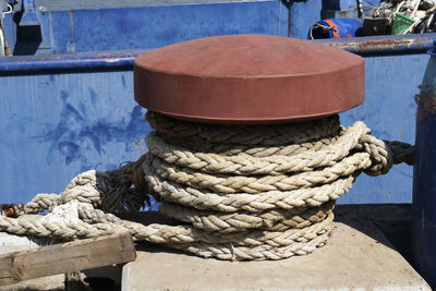 Close-up of rope tied to wooden post in harbor