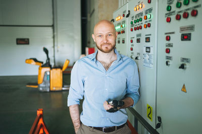 Adult bald smiling attractive man forty years with beard in blue shirt businessman