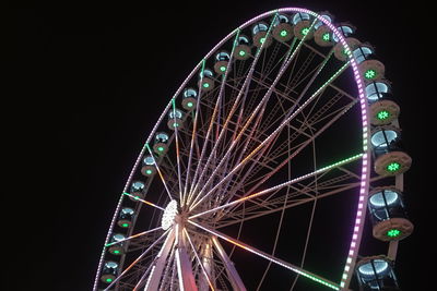 Low angle view of illuminated ferris wheel against sky at night